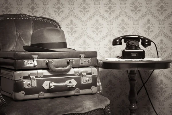 Hat and suitcases on elegant armchair — Stock Photo, Image