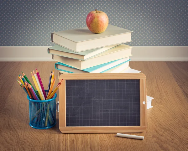 Chalkboard, apple and colorful stationery. — Stock Photo, Image