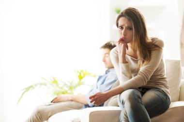 Woman and her boyfriend sitting on sofa. clipart