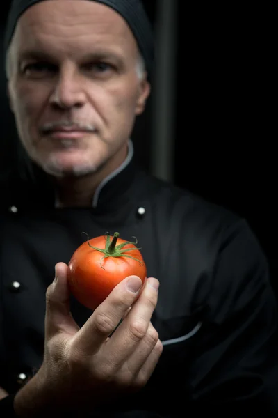 Šéfkuchař drží rajče — Stock fotografie