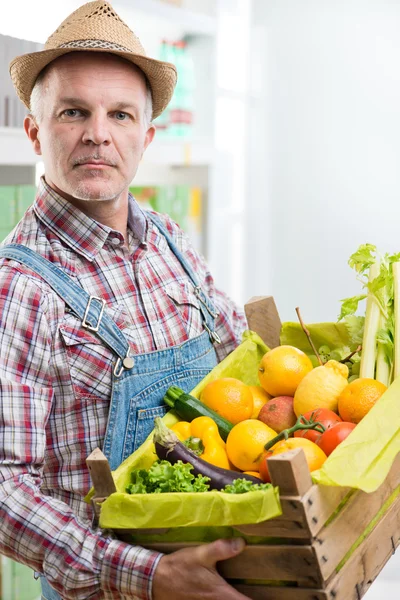 Bauer hält eine Holzkiste — Stockfoto