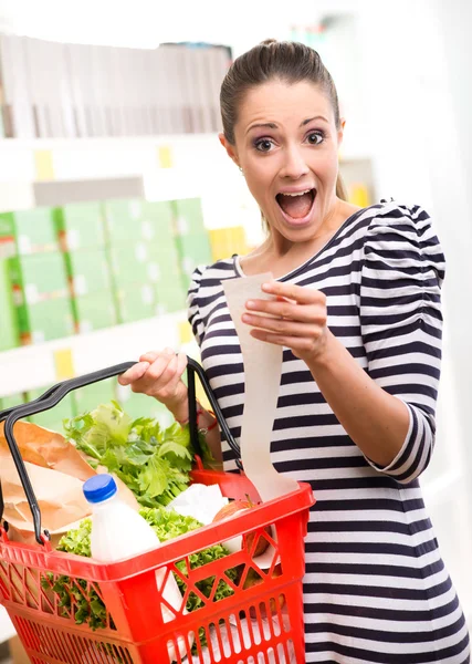 Femme vérifiant un reçu d'épicerie . — Photo