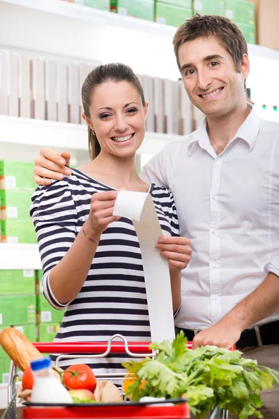 Ehepaar hält Lebensmittelquittung in der Hand — Stockfoto