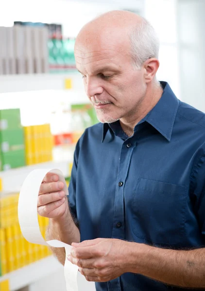 Man checking grocery receipt — Stock Photo, Image