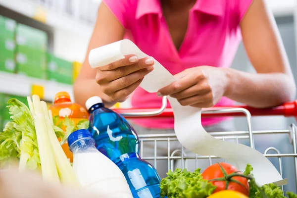 Frau überprüft Lebensmittelquittung — Stockfoto