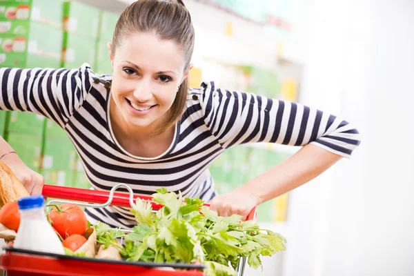 Donna che spinge un carrello — Foto Stock