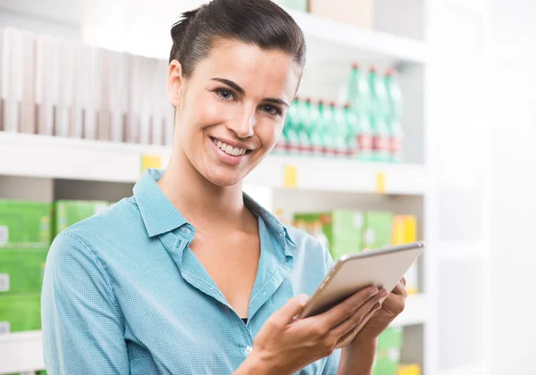 Frau hält Tablette im Supermarkt — Stockfoto