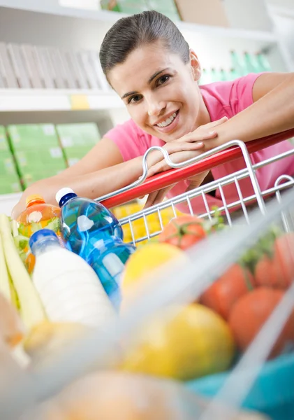 Mujer inclinada a un carrito de compras — Foto de Stock