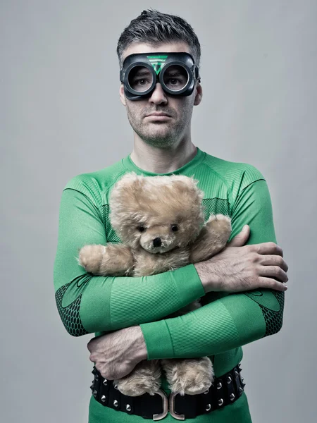 Lonely superhero holding a teddy bear — Stock Photo, Image