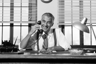 1950'lerde gülümseyen iş adamı telefonda