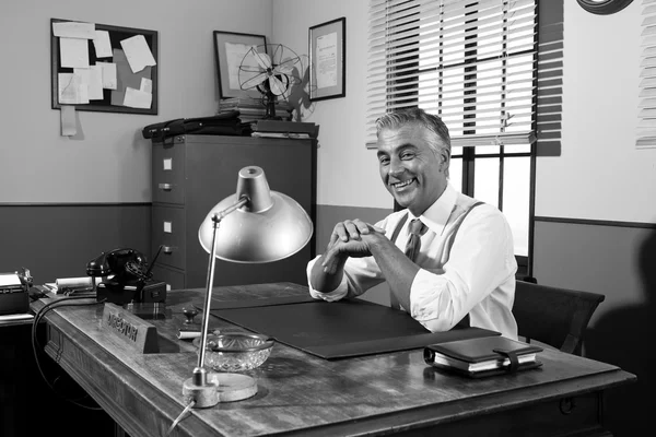 Sorrindo diretor vintage sentado na mesa de escritório — Fotografia de Stock