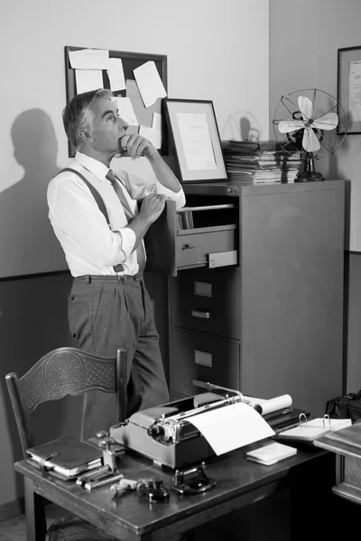 Nachdenkliche Büroangestellte auf der Suche nach einer Akte im Schrank — Stockfoto
