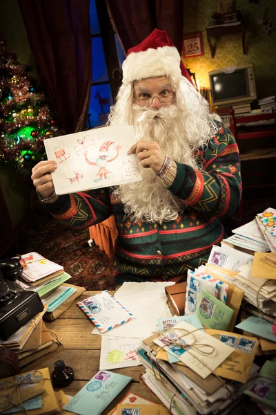 Santa Claus mostrando dibujo infantil — Foto de Stock