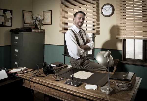 Businessman sitting on desk — Stock Photo, Image