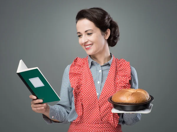 Retro huisvrouw met kookboek — Stockfoto