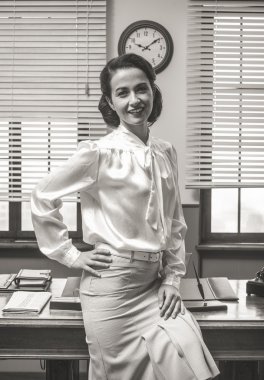 Sekreter masasında yaslanmış