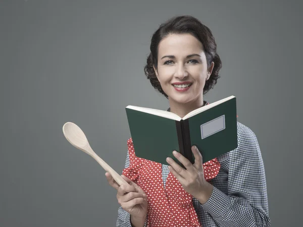 Mulher segurando um livro de receitas aberto — Fotografia de Stock