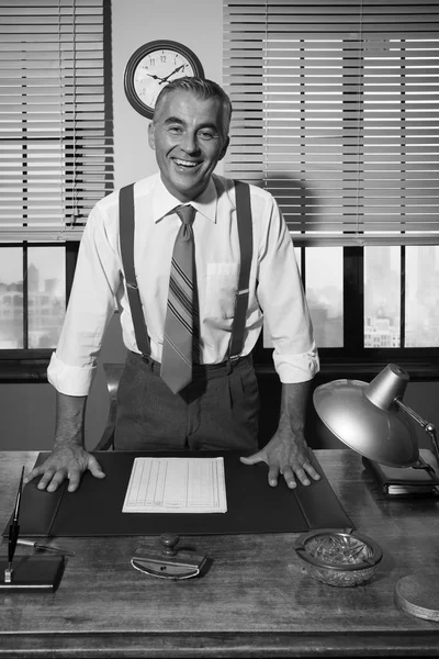 Businessman leaning to office desk — Stock Photo, Image