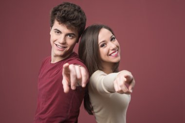 Happy young couple pointing
