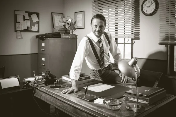 Businessman sitting on desk — Stock Photo, Image