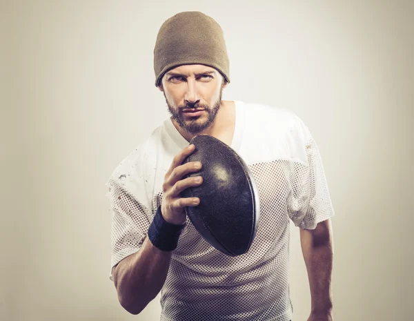 Guapo jugador de fútbol sosteniendo pelota — Foto de Stock