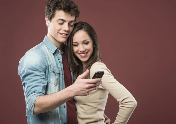 Teen couple with smartphone — Stock Photo, Image