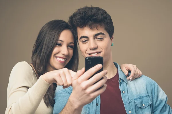 Mladý pár s mobilním telefonem — Stock fotografie