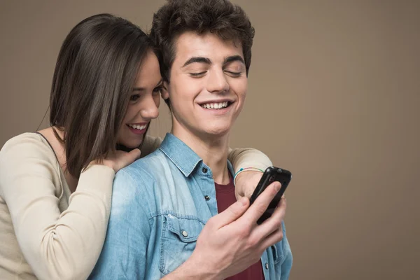 Cheerful young couple with mobile phone — Stock Photo, Image