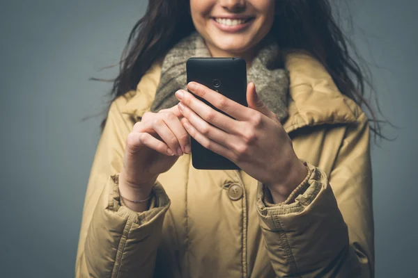 Mulher sorridente com telefone inteligente — Fotografia de Stock