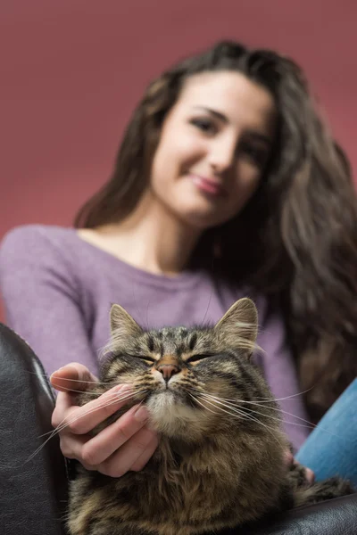 Genç kadın bir kedi sarılma — Stok fotoğraf