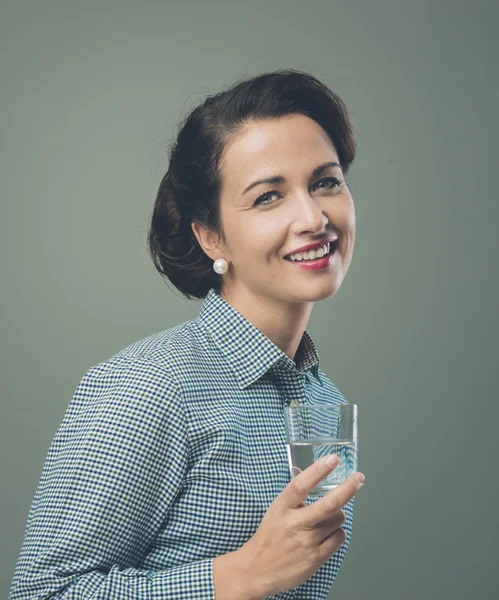 Mulher sorridente bebendo um copo de água — Fotografia de Stock