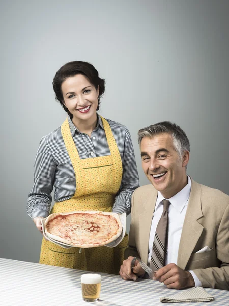 Wife is serving a pizza to husband — Stock Photo, Image