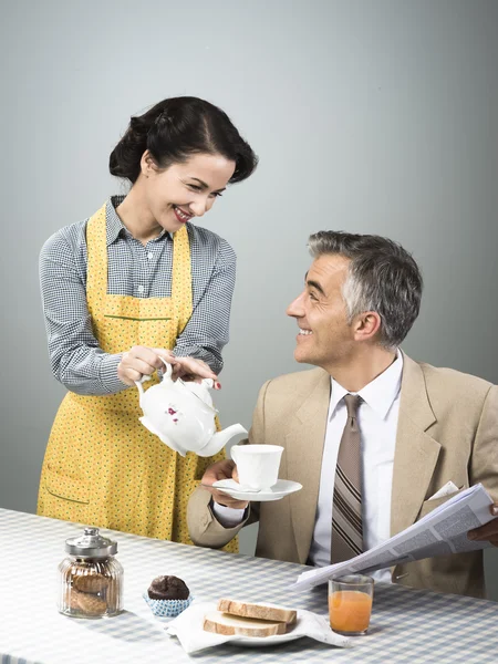 Woman serving tea to her husband