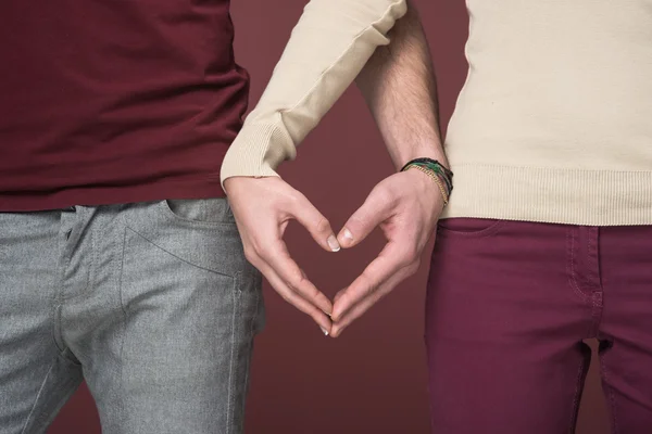 Casal compondo uma forma de coração com as mãos — Fotografia de Stock