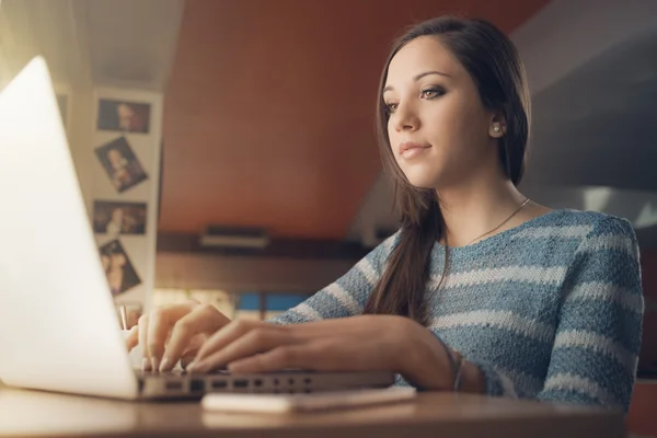 Bir dizüstü bilgisayar kullanan meşgul kadın — Stok fotoğraf
