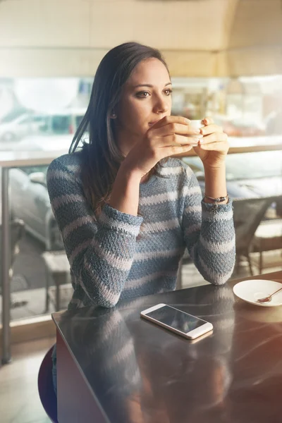 Vrouw die een kop koffie drinkt — Stockfoto