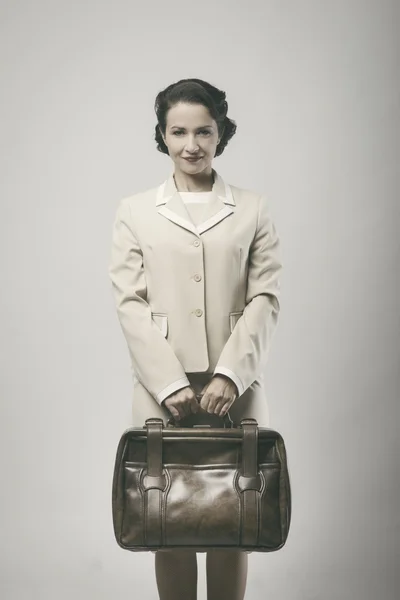 Woman smiling and holding briefcase — Stock Photo, Image