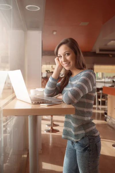 Woman at bar using laptop — Stock Photo, Image