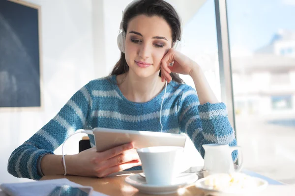 Vrouw in cafe met hoofdtelefoons — Stockfoto