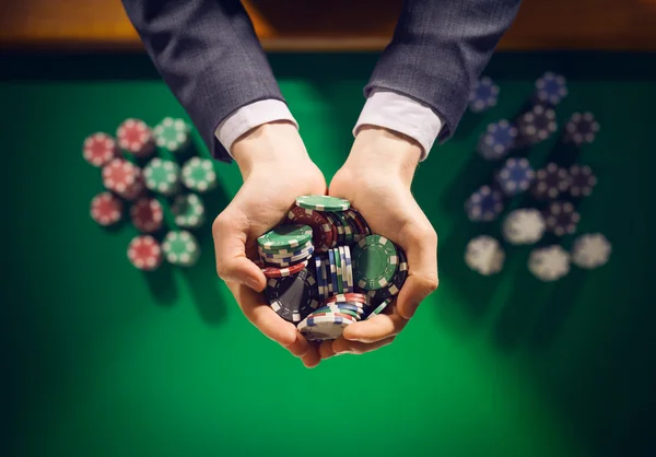 Casino juega sosteniendo un puñado de fichas — Foto de Stock