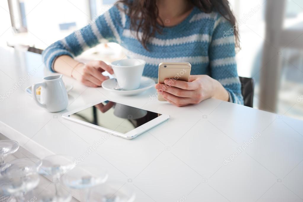 Woman at cafe using mobile phone