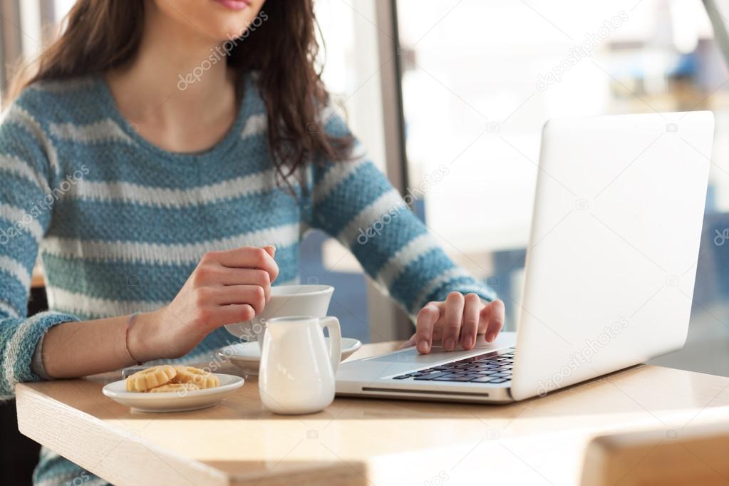 Woman at cafe using laptop