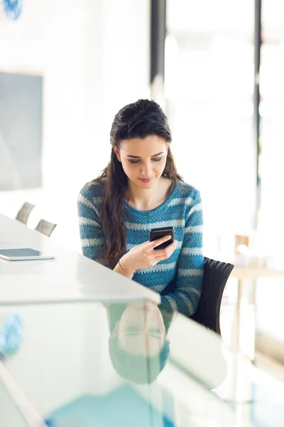 Bir akıllı telefon kullanan genç kadın — Stok fotoğraf