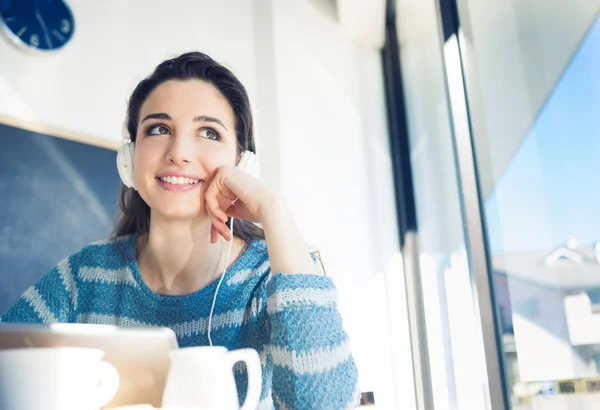 Menina no café usando fones de ouvido — Fotografia de Stock