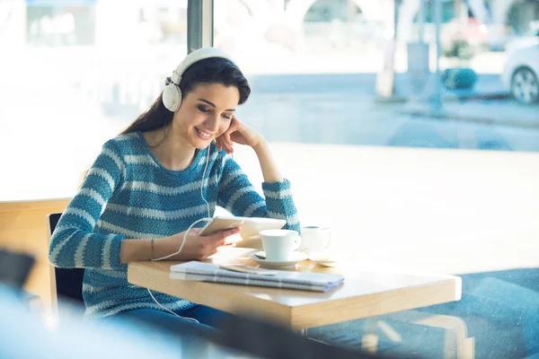 Kvinna på café med hörlurar — Stockfoto