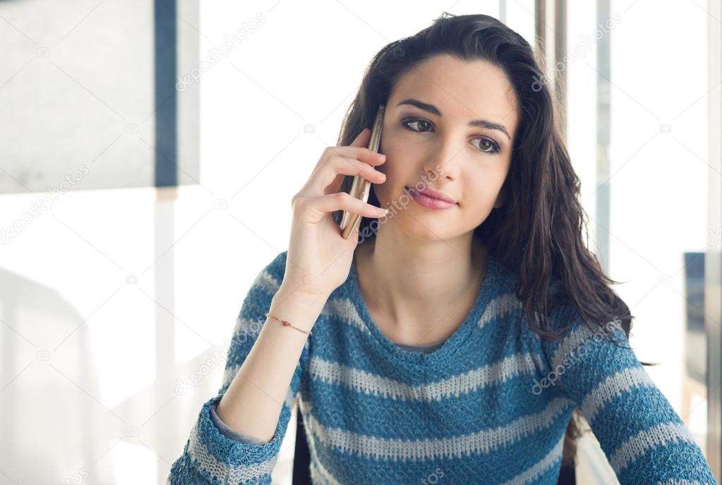 Woman at cafe table and phone calling