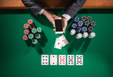 Erkek poker oyuncusu bir smartphone kullanarak