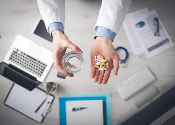 Doctor dando un montón de pastillas —  Fotos de Stock