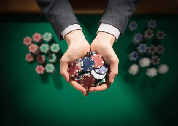 Jogador de casino segurando punhado de fichas — Fotografia de Stock