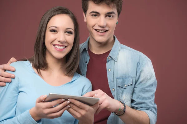 Leende tonåringar med hjälp av en digital tablet — Stockfoto